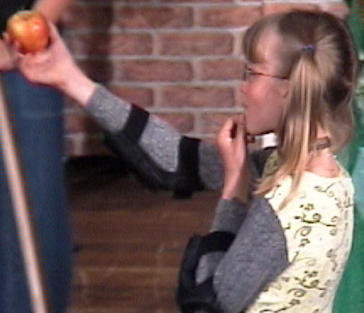 Verz�ckt h�lt Emma ihren Apfel in den H�nden.